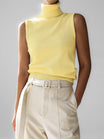 Sleeveless knit top for women featuring a soft turtleneck design and ribbed hem, perfect for layering or wearing alone. 1