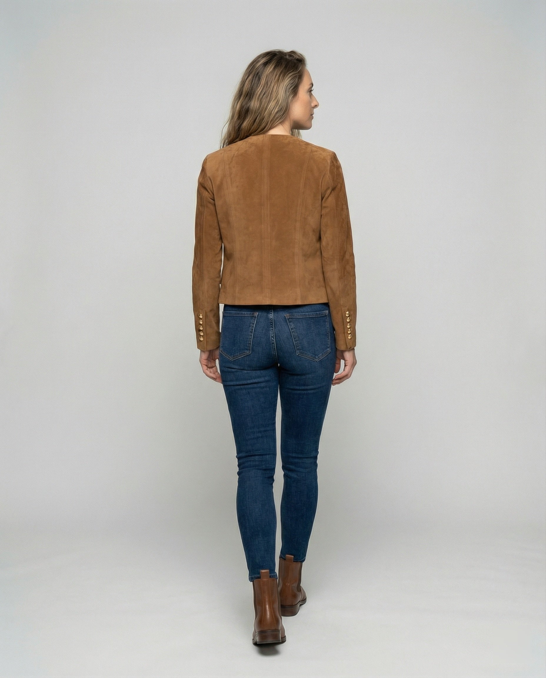 Tan suede jacket featuring a gold button front and a stylish collarless neckline, designed in a cropped tailored fit for a chic, modern look. 2