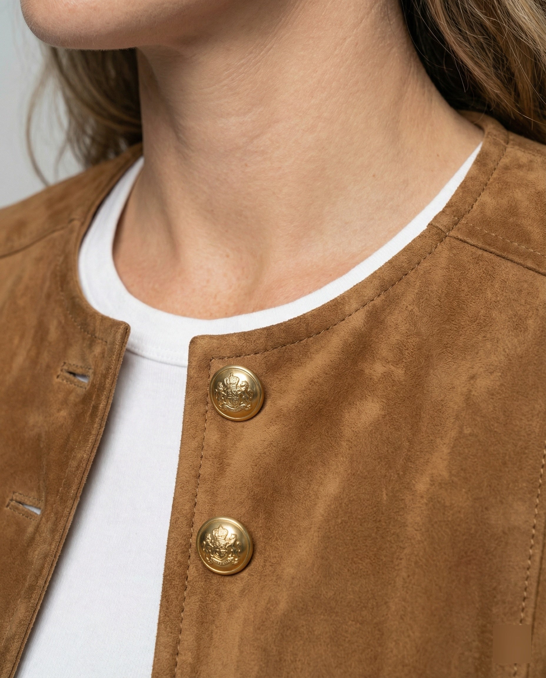 Tan suede jacket featuring a gold button front and a stylish collarless neckline, designed in a cropped tailored fit for a chic, modern look. 3