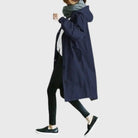 Waterproof trench coat for women featuring an adjustable belt, designed as a long raincoat in a timeless style for ultimate protection against the elements. 4