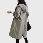 Waterproof trench coat for women featuring an adjustable belt, designed as a long raincoat in a timeless style for ultimate protection against the elements. 6