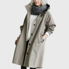 Waterproof trench coat for women featuring a hood and adjustable belt, ideal for stylish protection against rain. 0