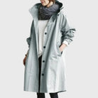 Waterproof trench coat for women featuring a hood and adjustable belt, ideal for stylish protection against rain. 2