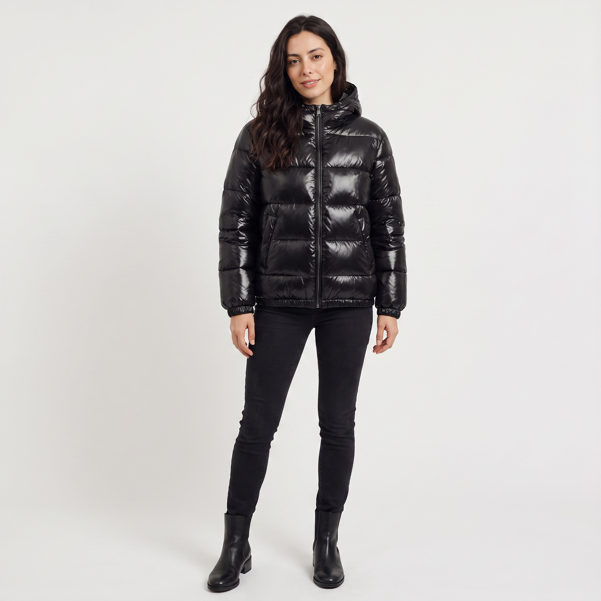 Women's black puffer jacket featuring a stylish attached hood, glossy quilted design, and convenient zip pockets, designed for a relaxed fit perfect for winter wear 2