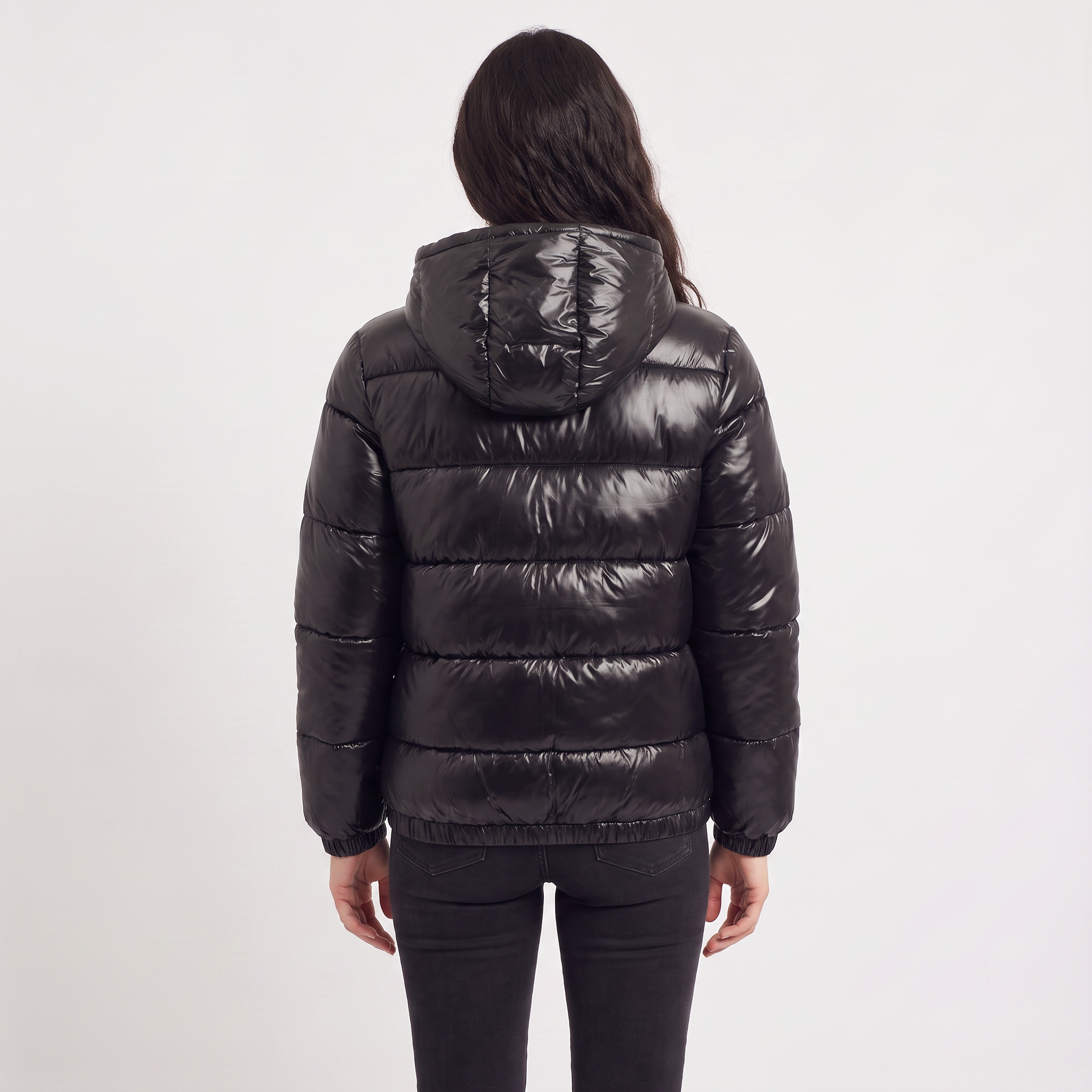 Women's black puffer jacket featuring a stylish attached hood, glossy quilted design, and convenient zip pockets, designed for a relaxed fit perfect for winter wear 5