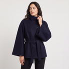 Women's oversized winter coat featuring a high collar and adjustable belt, designed for warmth and style, perfect for cold weather fashion. 0