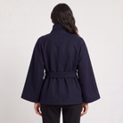 Women's oversized winter coat featuring a high collar and adjustable belt, designed for warmth and style, perfect for cold weather fashion. 4