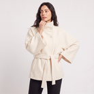 Women's oversized winter coat featuring a high collar and adjustable belt, designed for warmth and style, perfect for cold weather fashion. 6