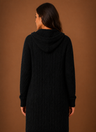 Women's black cardigan with hood and deep pockets, featuring a chunky cable knit design and mid-long duster length, perfect for layering in cooler weather. 1