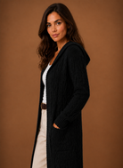 Women's black cardigan with hood and deep pockets, featuring a chunky cable knit design and mid-long duster length, perfect for layering in cooler weather. 3