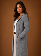 Women's black cardigan with hood and deep pockets, featuring a chunky cable knit design and mid-long duster length, perfect for layering in cooler weather. 6