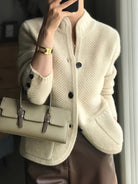 Women's cardigan featuring a structured stand collar and statement buttons, crafted from textured honeycomb knit in a stylish apricot and brown color palette. 1