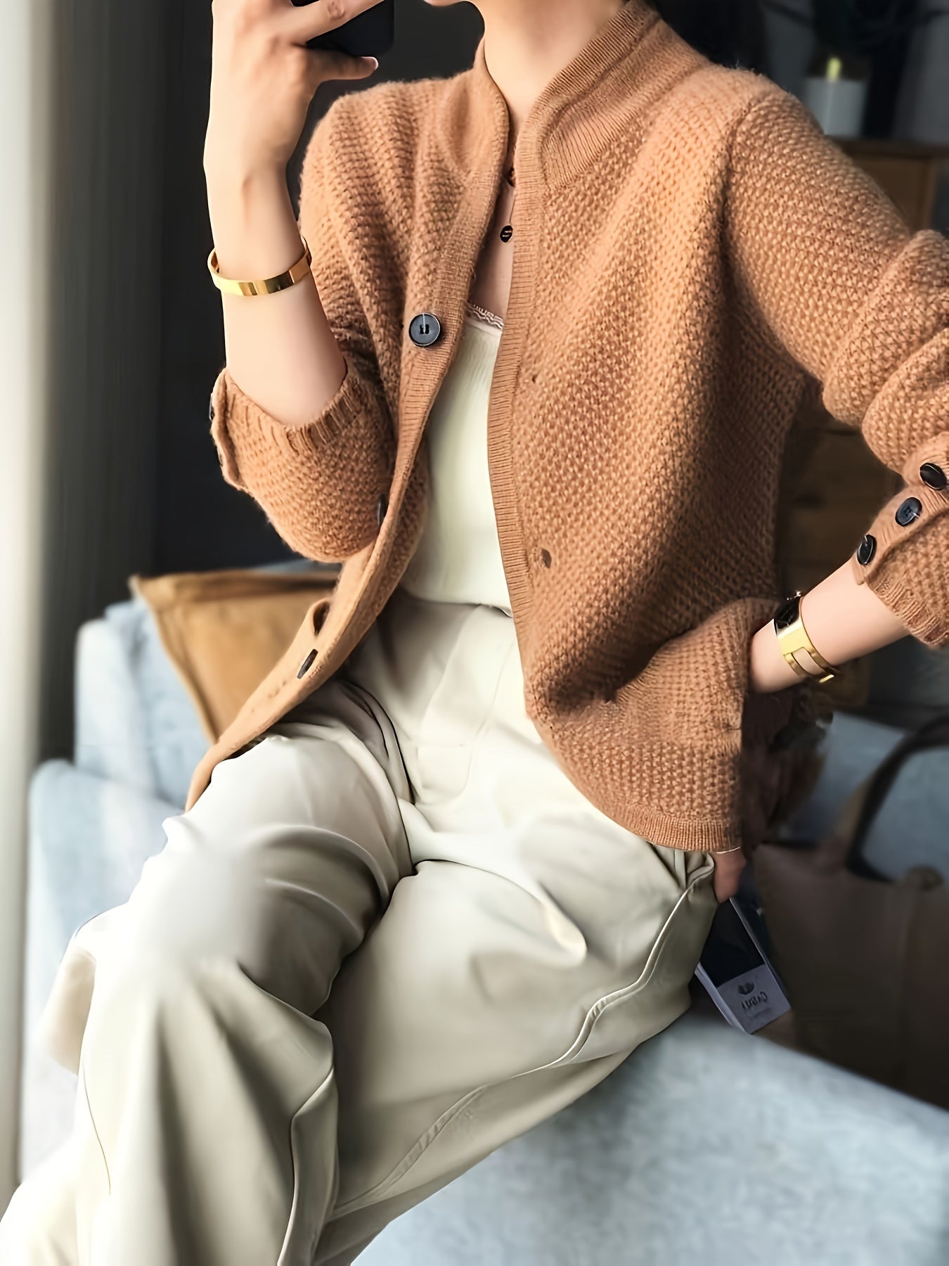 Women's cardigan featuring a structured stand collar and statement buttons, crafted from textured honeycomb knit in a stylish apricot and brown color palette. 3
