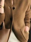 Women's cardigan featuring a structured stand collar and statement buttons, crafted from textured honeycomb knit in a stylish apricot and brown color palette. 5