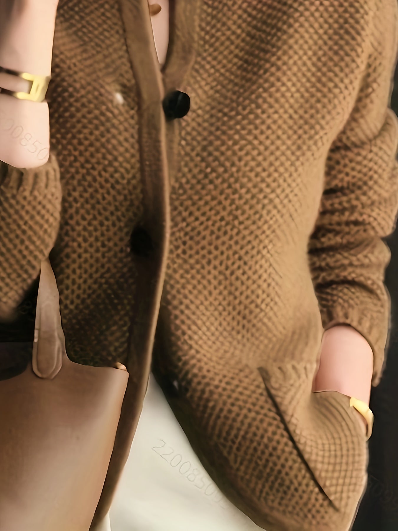 Women's cardigan featuring a structured stand collar and statement buttons, crafted from textured honeycomb knit in a stylish apricot and brown color palette. 5