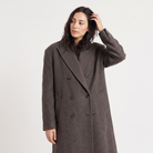 Women's oversized winter coat featuring a double-breasted closure and front pockets, designed for a relaxed fit and stylish warmth. 2
