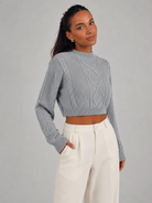 Women's cropped cable knit jumper featuring a mock neck and blouson sleeves, designed with a chunky knit for a cozy and stylish look. 0