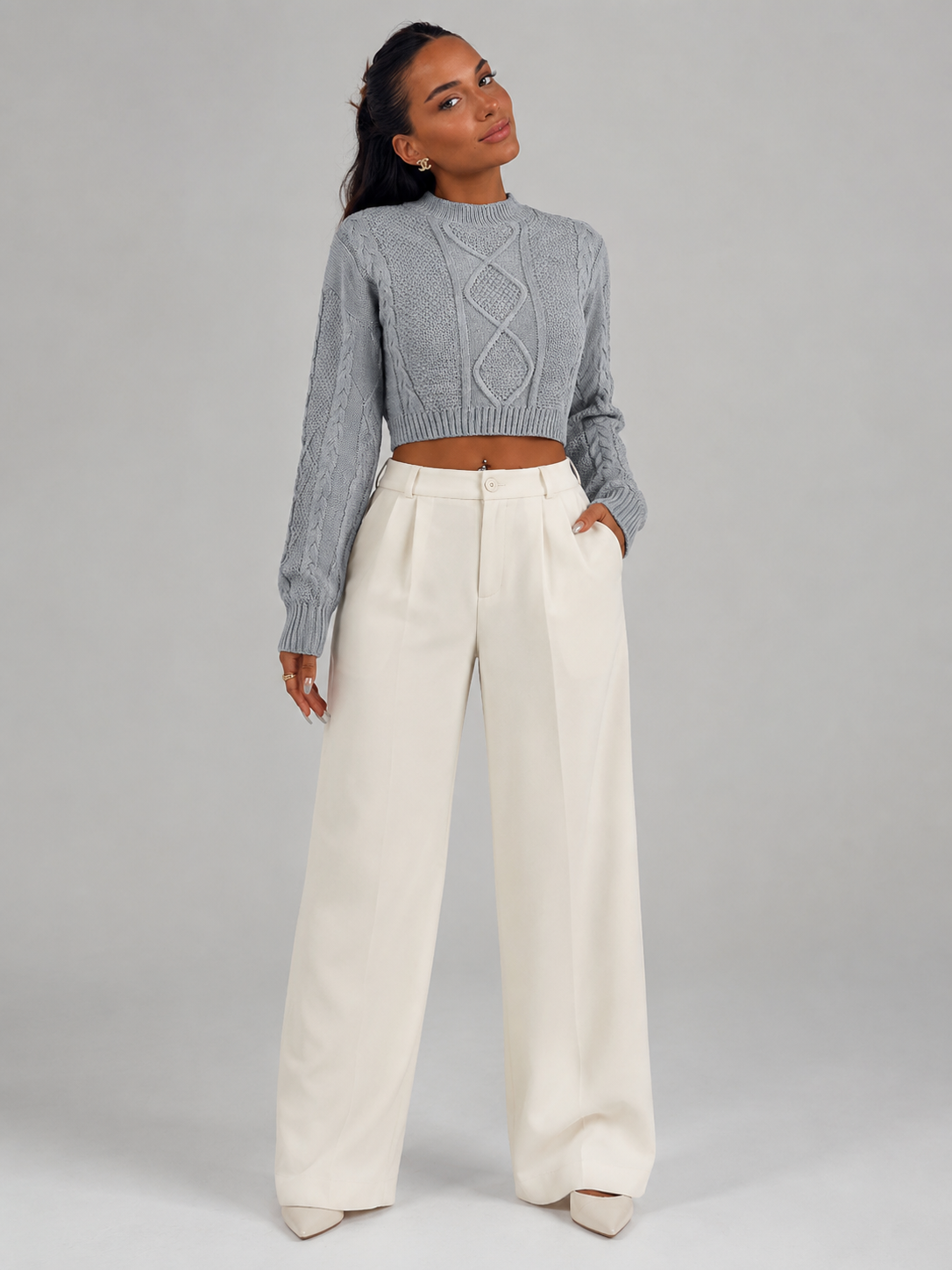 Women's cropped cable knit jumper featuring a mock neck and blouson sleeves, designed with a chunky knit for a cozy and stylish look. 1