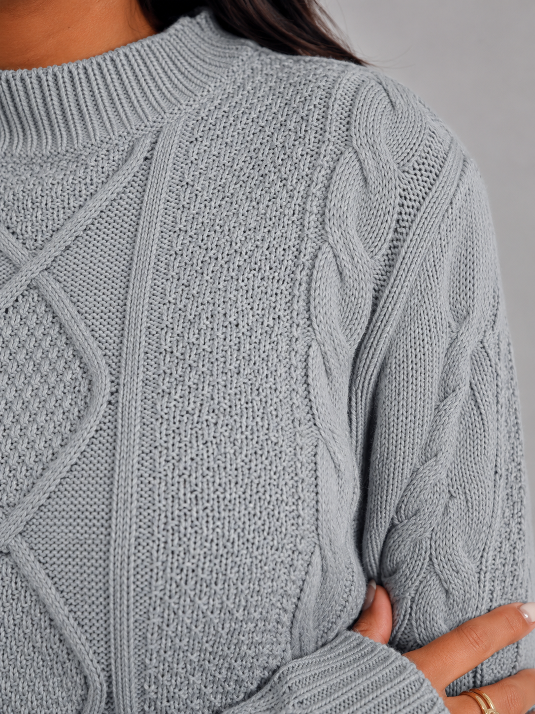 Women's cropped cable knit jumper featuring a mock neck and blouson sleeves, designed with a chunky knit for a cozy and stylish look. 5