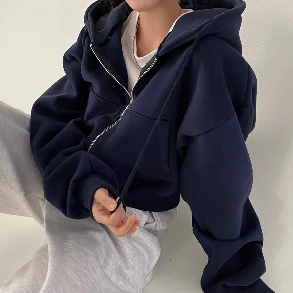 Women's cropped hoodie with zip front and adjustable hood, featuring an oversized fleece design, available in multiple colors for stylish comfort. 0