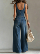 Women's denim jumpsuit featuring a V-neckline and wide-leg pants, elegantly designed in classic blue with a stylish sleeveless cut. 4