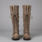 Women's black faux leather knee-high boots featuring a lace-up front, block heel, and stylish stud detail. 7