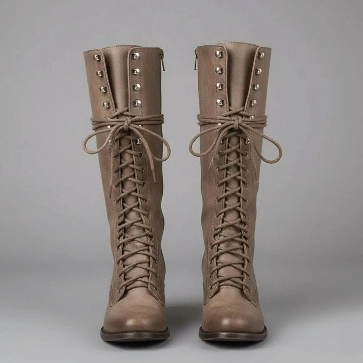 Women's black faux leather knee-high boots featuring a lace-up front, block heel, and stylish stud detail. 7