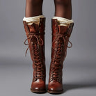 Women's black faux leather knee-high boots featuring a lace-up front, block heel, and stylish stud detail. 9