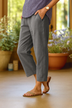 Women's linen pants with an elastic waistband, featuring a casual cropped summer style and breathable relaxed fit, perfect for warm weather outings. 1
