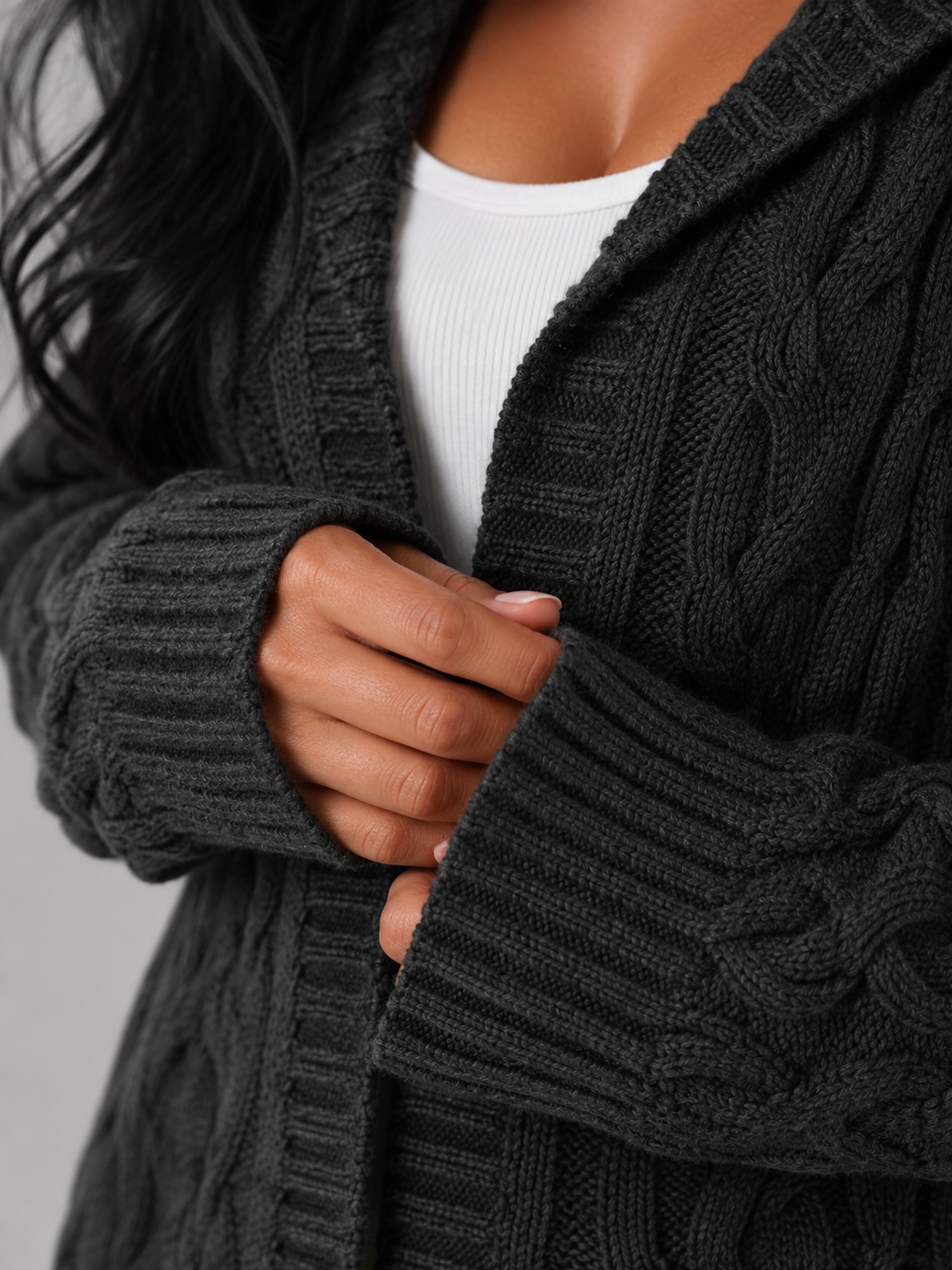 Women's long cardigan sweater featuring a cozy hood and functional pockets, designed with a chunky cable knit pattern and an open front for a stylish and comfortable look. 6