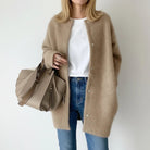 Women's long black cardigan featuring a button front and round neck, perfect for cozy layering in any season. 0