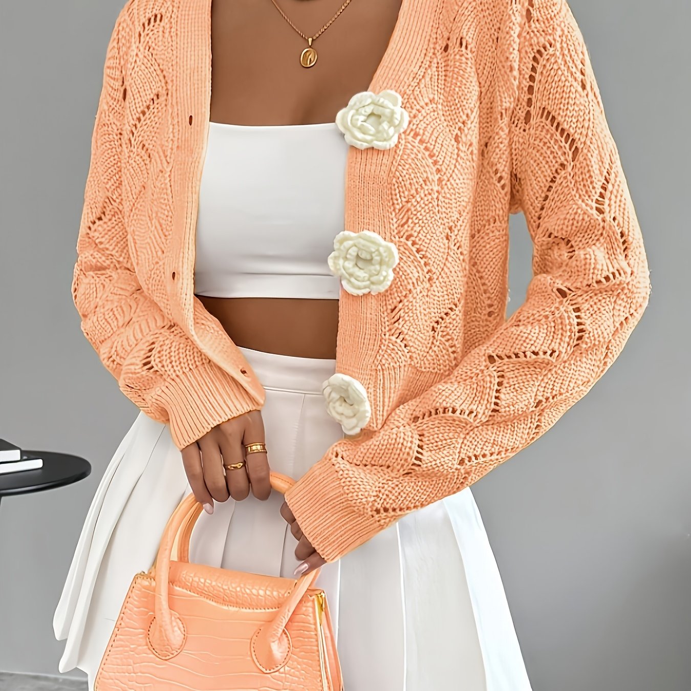 Elegant white women's long cardigan featuring an open crochet design and decorative floral buttons, perfect for layering in any season. 0