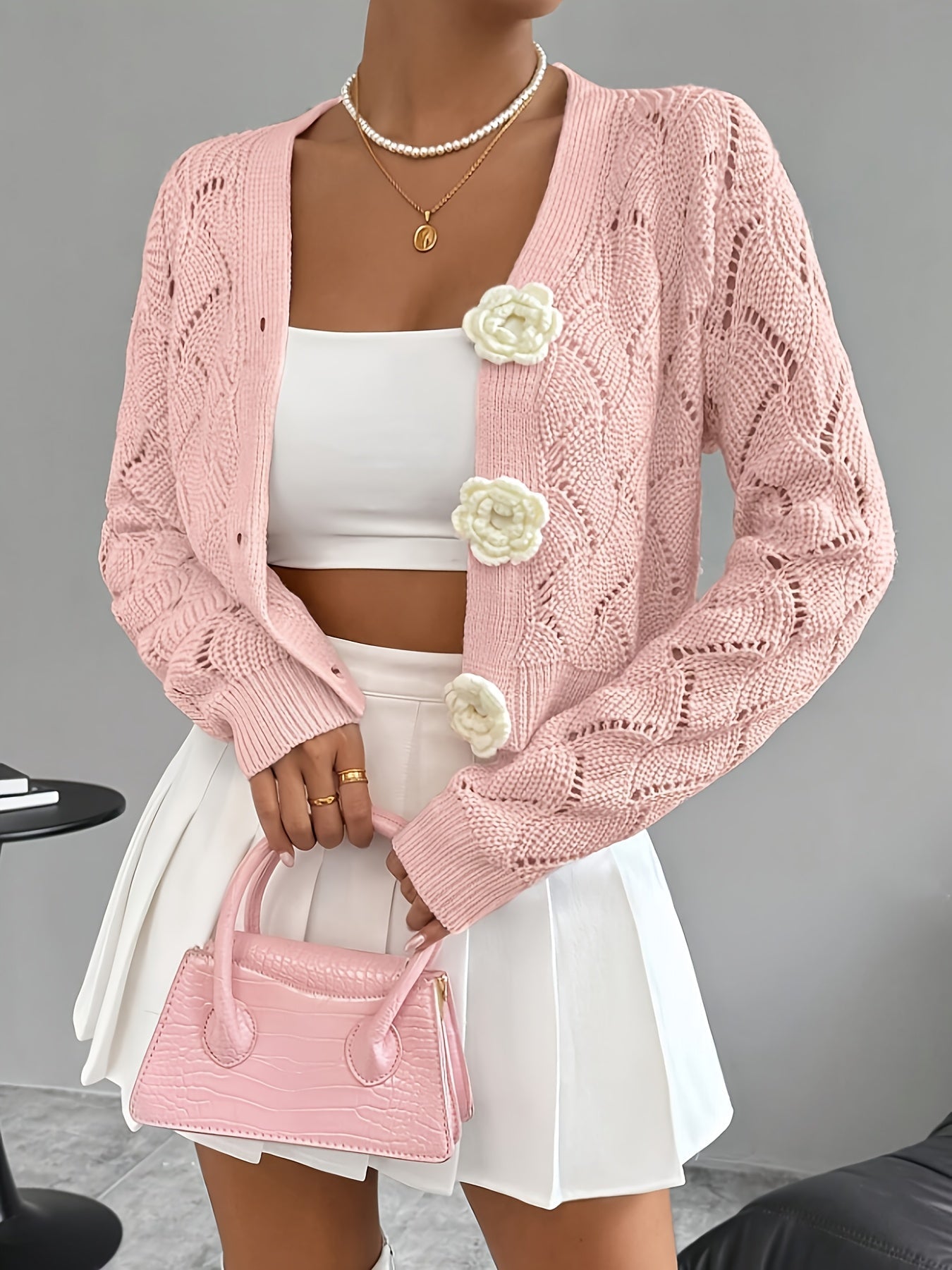 Elegant white women's long cardigan featuring an open crochet design and decorative floral buttons, perfect for layering in any season. 2