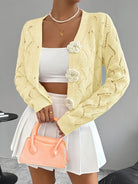 Elegant white women's long cardigan featuring an open crochet design and decorative floral buttons, perfect for layering in any season. 3