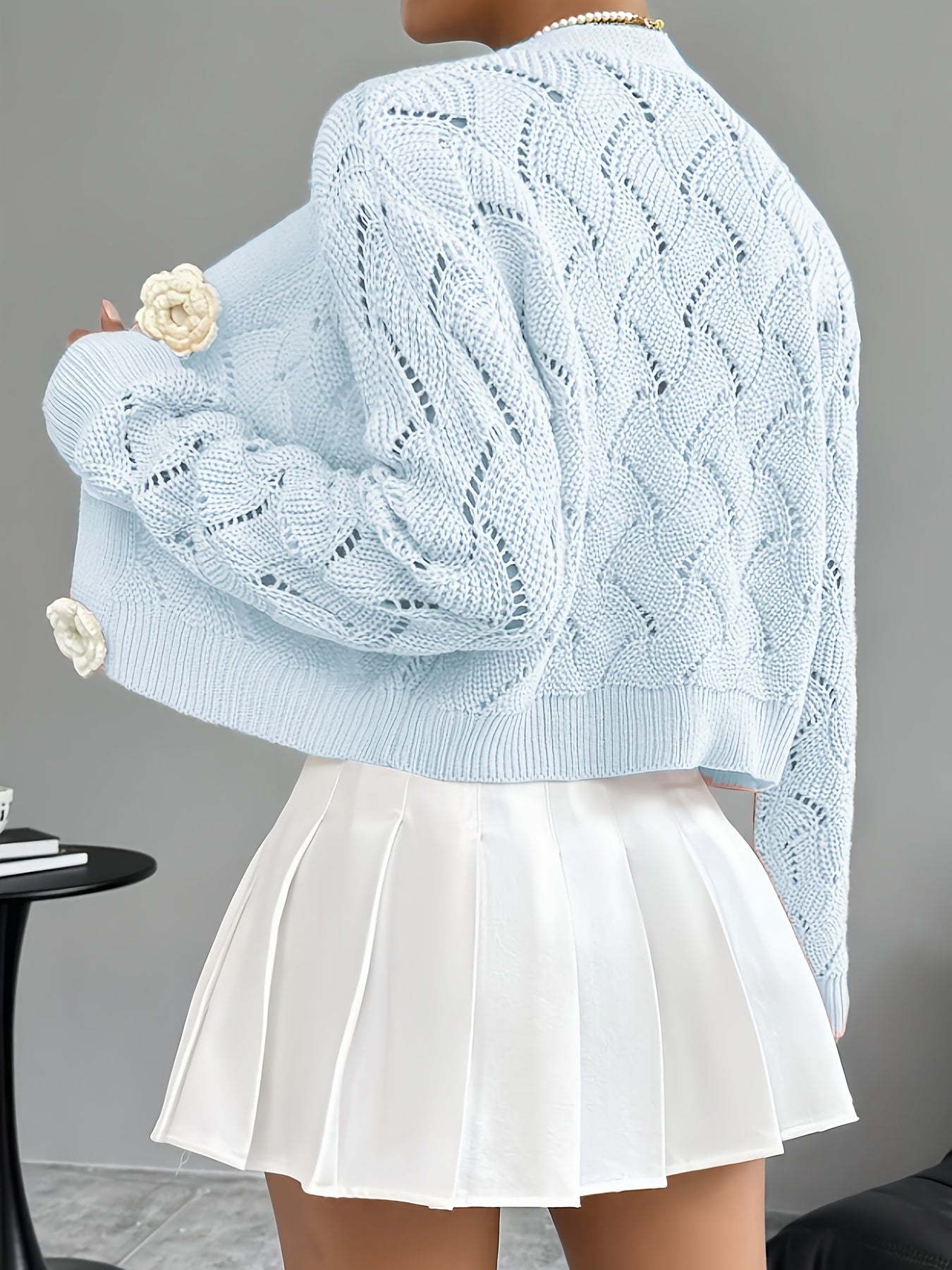 Elegant white women's long cardigan featuring an open crochet design and decorative floral buttons, perfect for layering in any season. 7