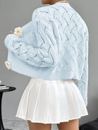 Elegant white women's long cardigan featuring an open crochet design and decorative floral buttons, perfect for layering in any season. 7