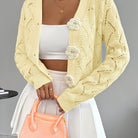 Elegant white women's long cardigan featuring an open crochet design and decorative floral buttons, perfect for layering in any season. 9