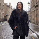 Women's longline faux fur coat featuring an oversized collar and a relaxed open-front design, perfect for stylish winter wear. 1