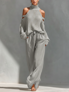 Women's outfit set featuring a beige cold-shoulder knit turtleneck top paired with wide-leg pants, showcasing a modern and comfortable style perfect for casual 2