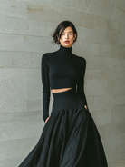Women's outfit set featuring a fitted turtleneck cropped top and long skirt in black, designed with stretch knit material for a minimalist look. 1