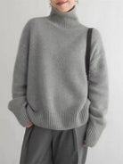 Women's oversized cashmere sweater featuring a cozy turtleneck design, crafted from soft knit fabric for ultimate comfort and warmth. 3