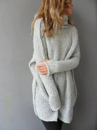 Women's oversized grey sweater featuring a chunky knit texture and high roll neck, perfect for cozy fall and winter outfits. 1