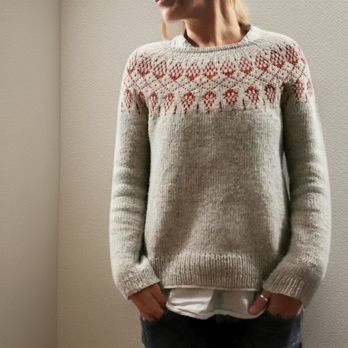 Light gray women's sweater featuring a Fair Isle knit design with red and cream patterns, designed for a relaxed fit. 0