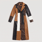 Women's trench coat featuring a stylish patchwork design in faux leather, showcasing a long structured silhouette in brown, black, and white colors. 5