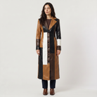 Women's trench coat featuring a stylish patchwork design in faux leather, showcasing a long structured silhouette in brown, black, and white colors. 6