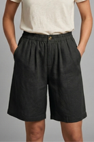Womens linen shorts featuring an elastic waist and side pockets, designed for a relaxed fit perfect for warm weather. 12