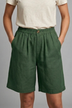 Womens linen shorts featuring an elastic waist and side pockets, designed for a relaxed fit perfect for warm weather. 2