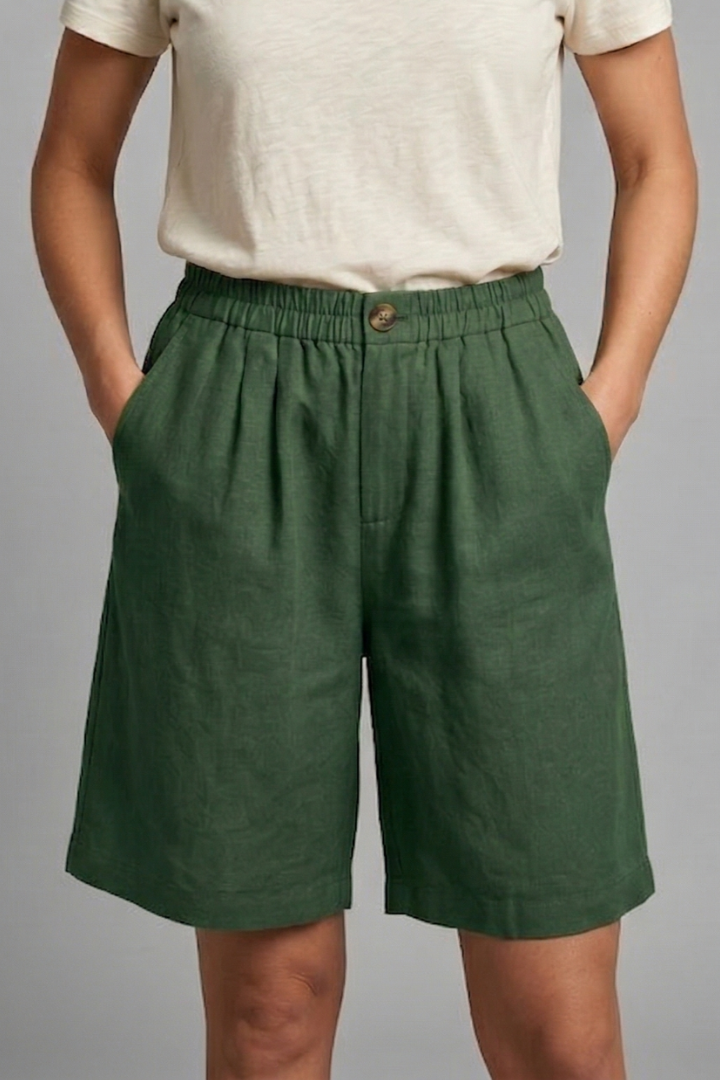 Womens linen shorts featuring an elastic waist and side pockets, designed for a relaxed fit perfect for warm weather. 2