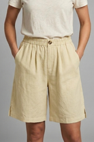 Womens linen shorts featuring an elastic waist and side pockets, designed for a relaxed fit perfect for warm weather. 4