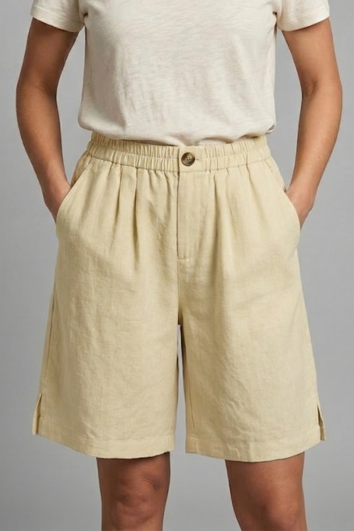 Womens linen shorts featuring an elastic waist and side pockets, designed for a relaxed fit perfect for warm weather. 4
